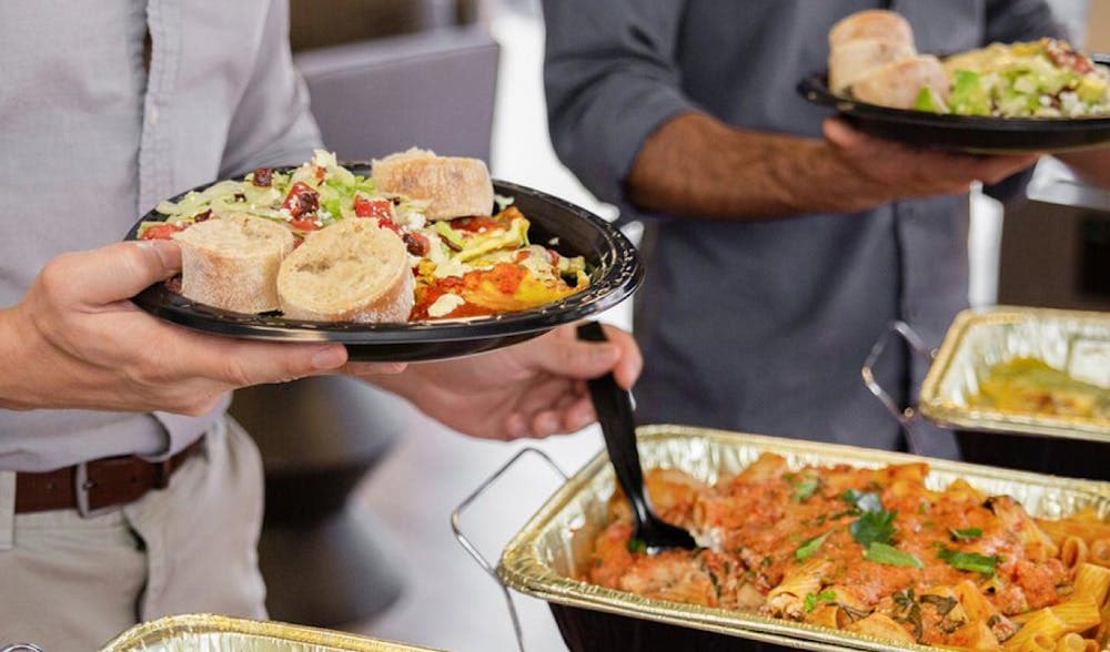 Catering Guests Filling Plates with Food from Trays
